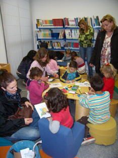 Madres y niños decoran la sala infantil de la Biblioteca Municipal de Lora.